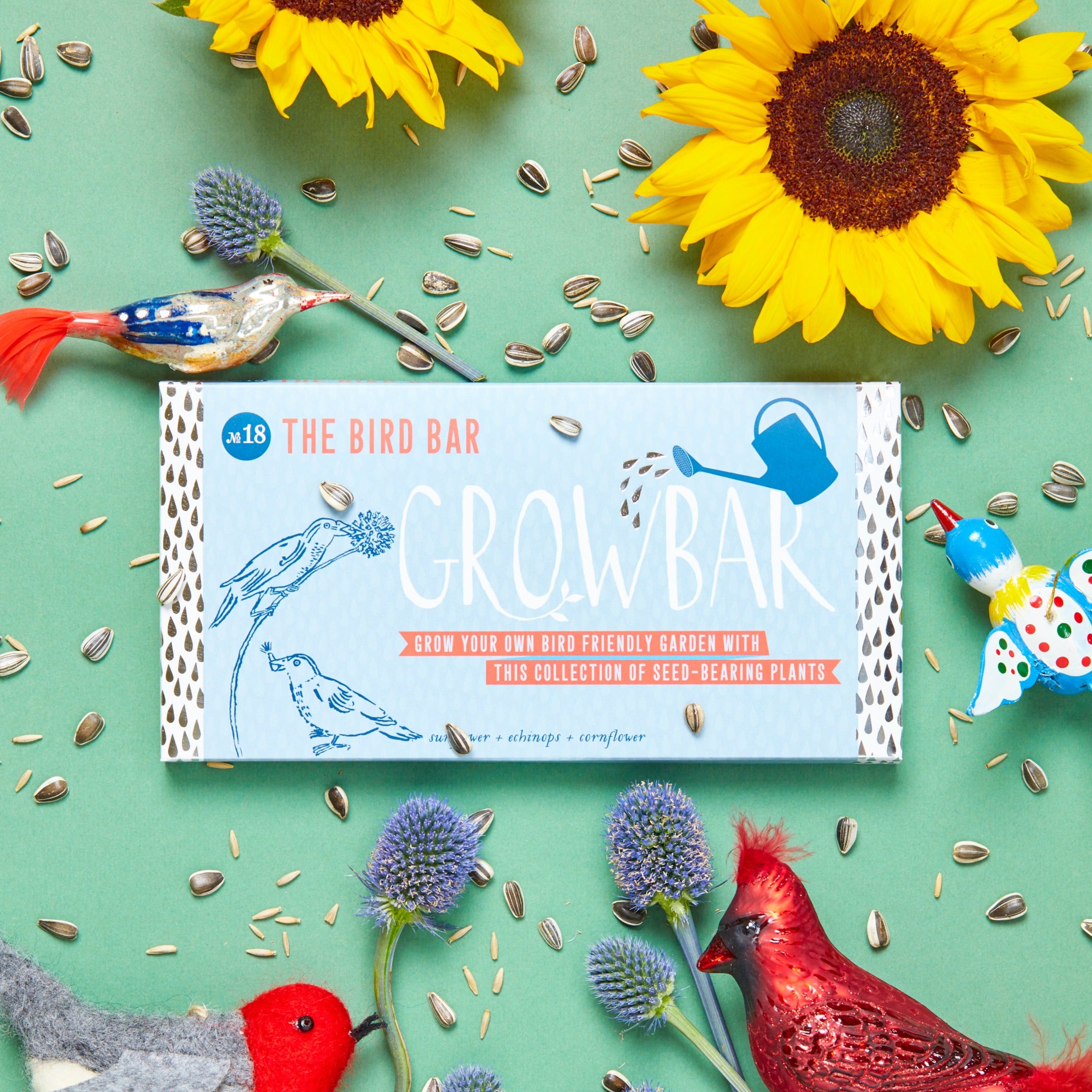 A Growbar- The Bird Bar product packaging with a background featuring sunflowers, echinops, and cornflowers, along with illustrated and photographic depictions of birds.