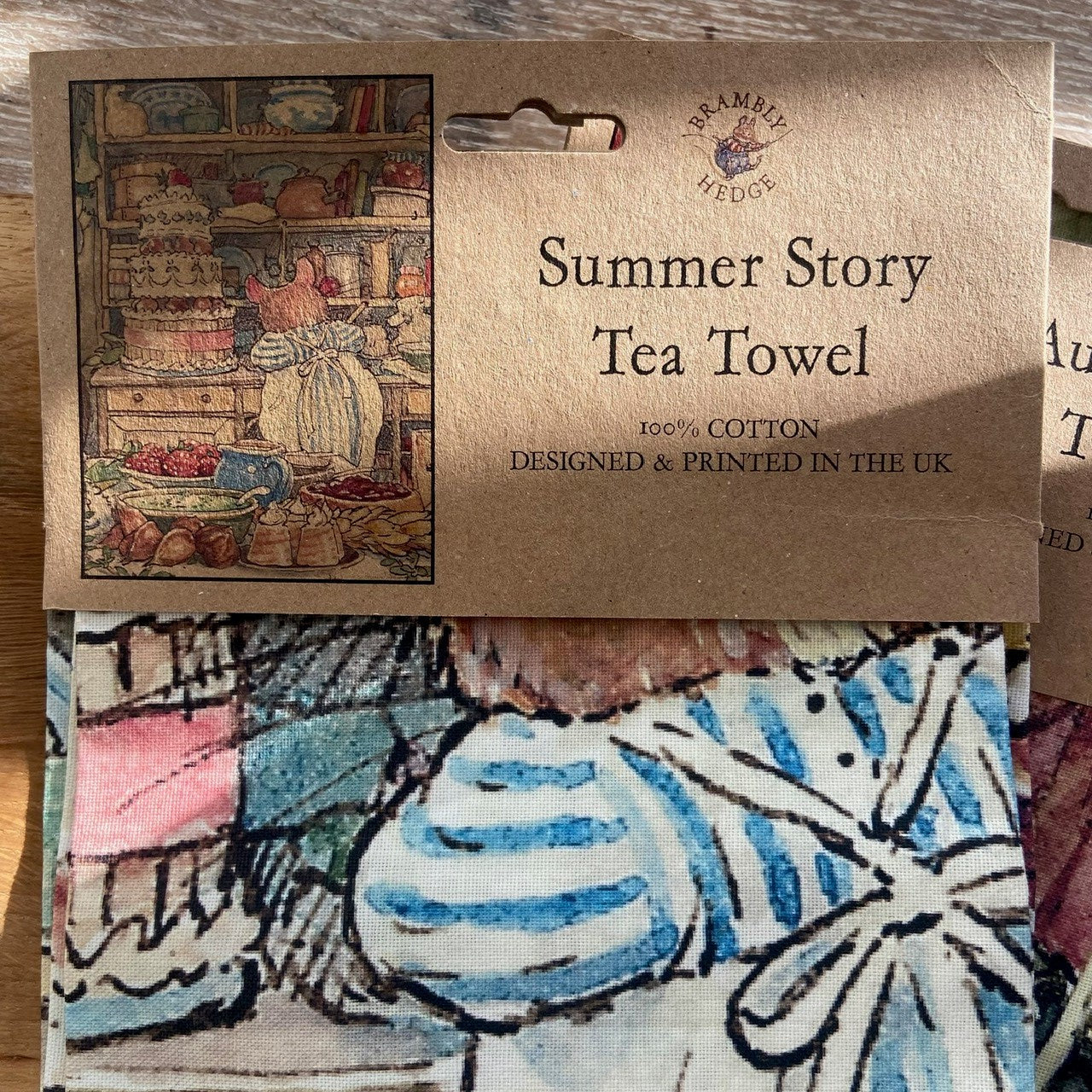 Tea towel with artistic design and brand label on a wooden surface