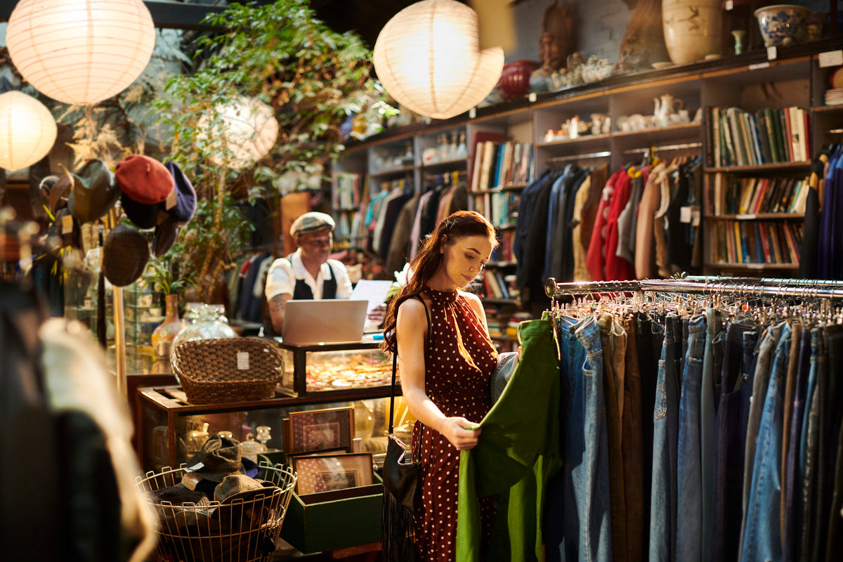 A woman looks through clothes at a second-hand shop