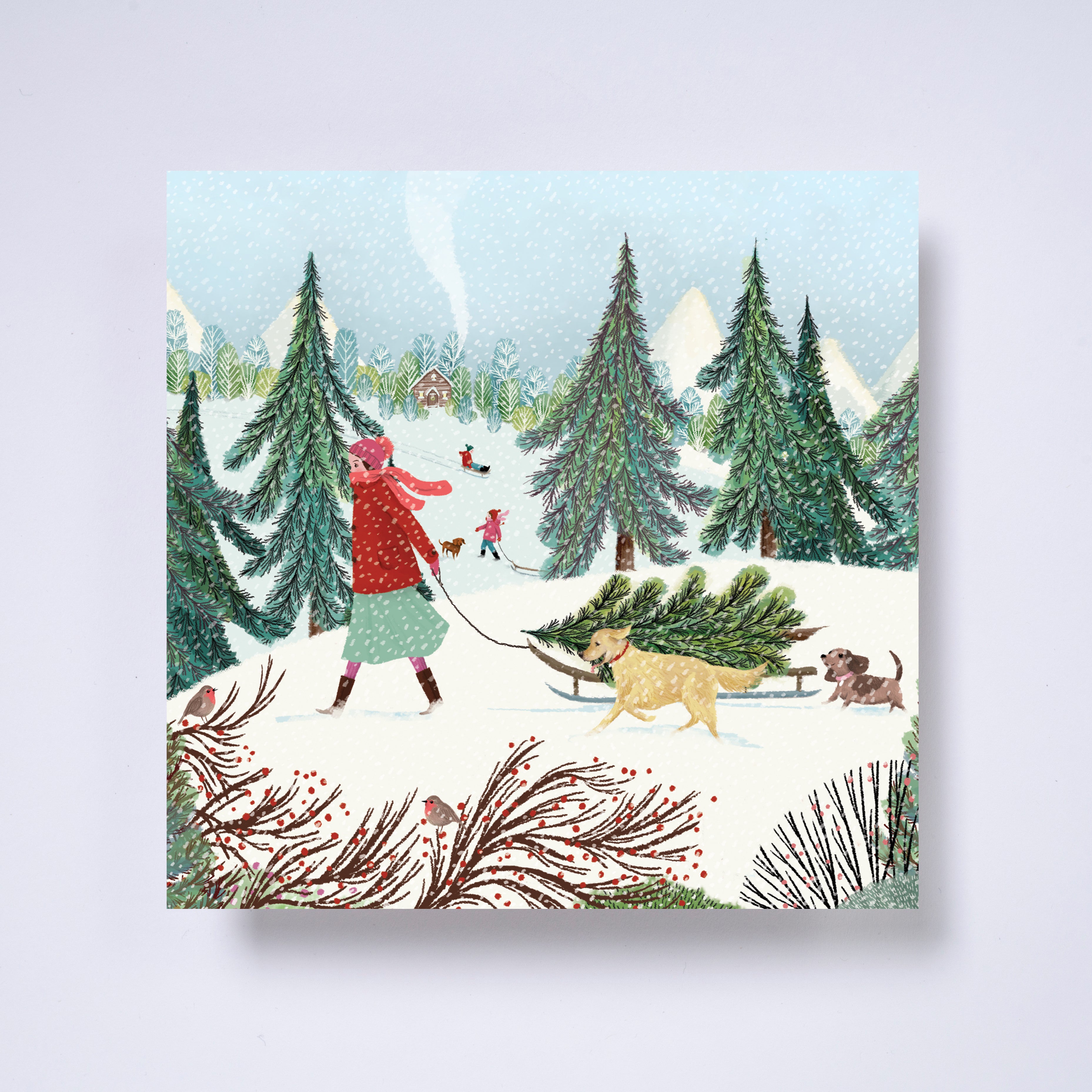 Winter walkies - Charity Christmas card from the British Red Cross of an illustration of a woman dragging a christmas tree on a sledge through the woods with her dogs following while it snows