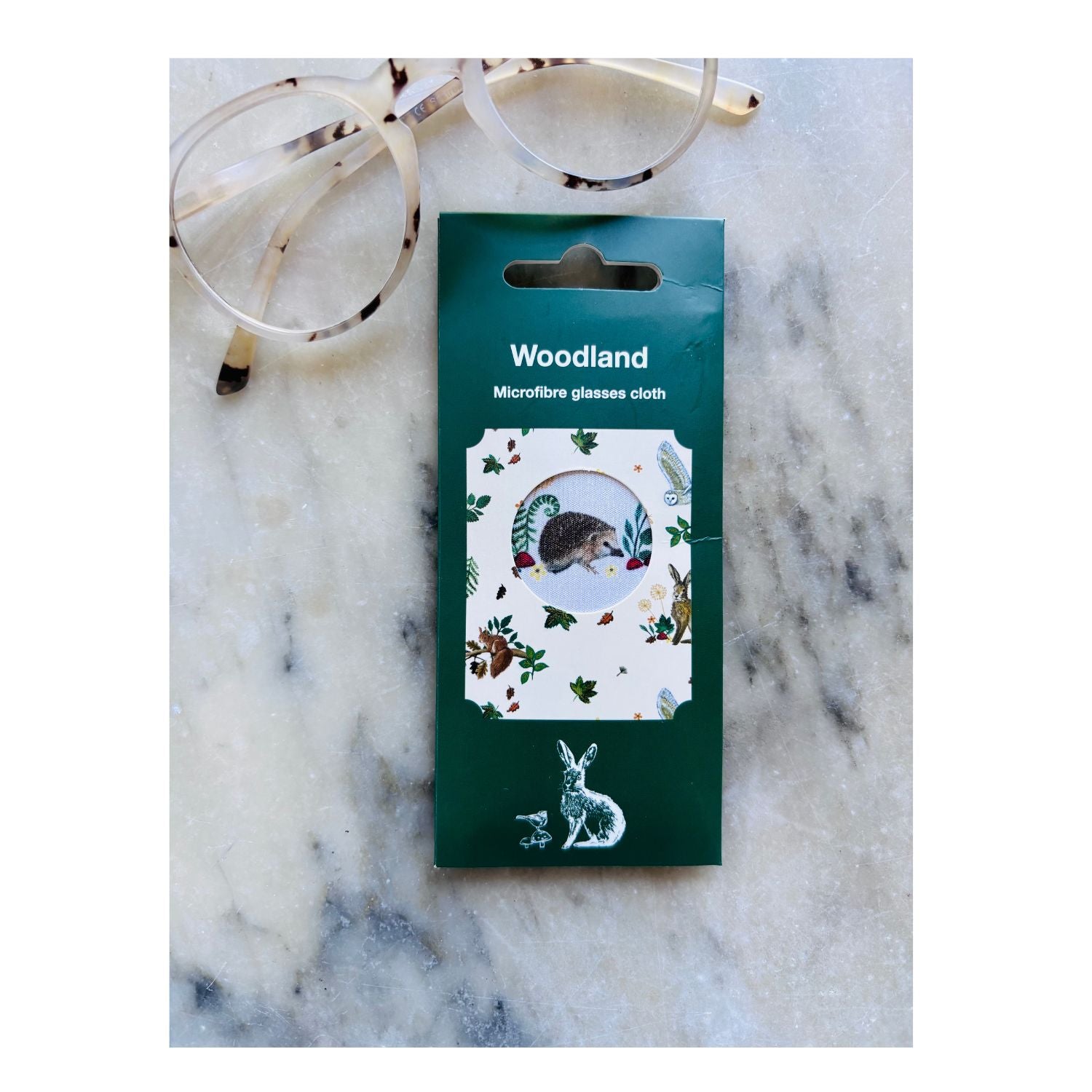 Packaged microfibre glasses cloth with woodland design on a marble surface