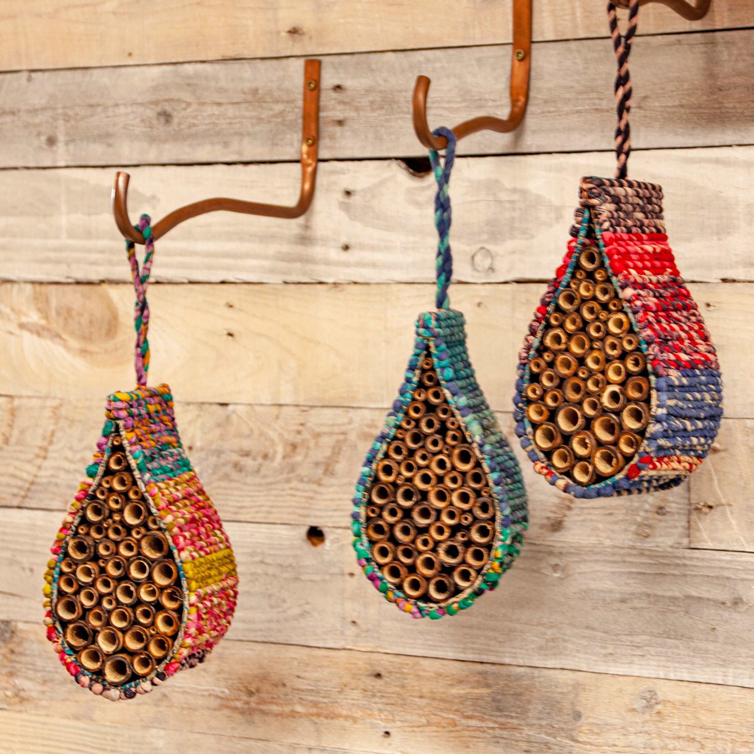 Image of three Artisan Bee Nesters hanging on a wooden wall 