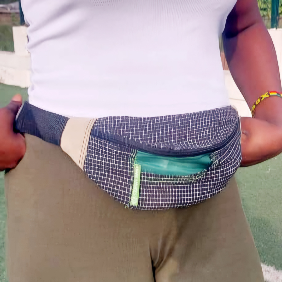 Person wearing a checkered fanny pack with a green pocket on a grassy background