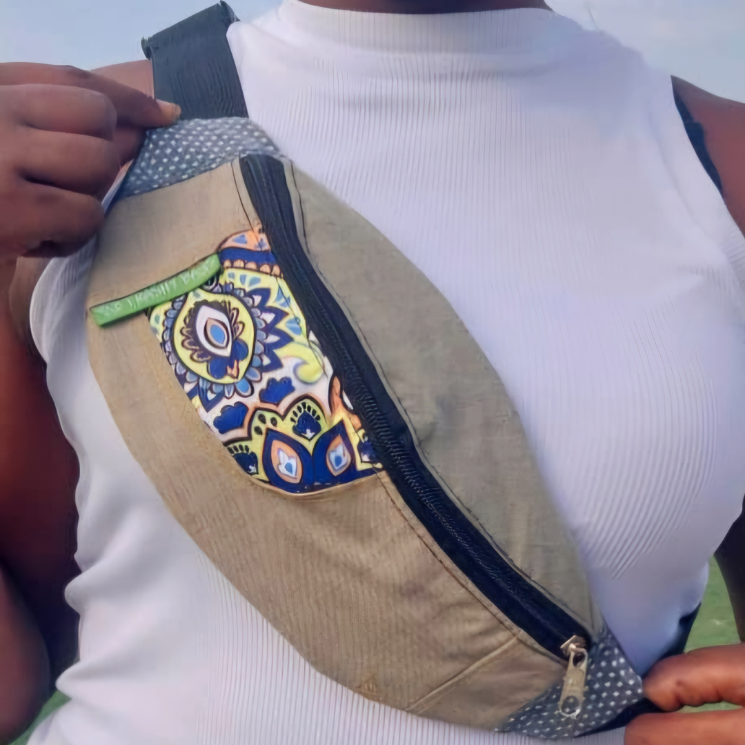 Person wearing a beige waist bag with a colorful patterned zipper