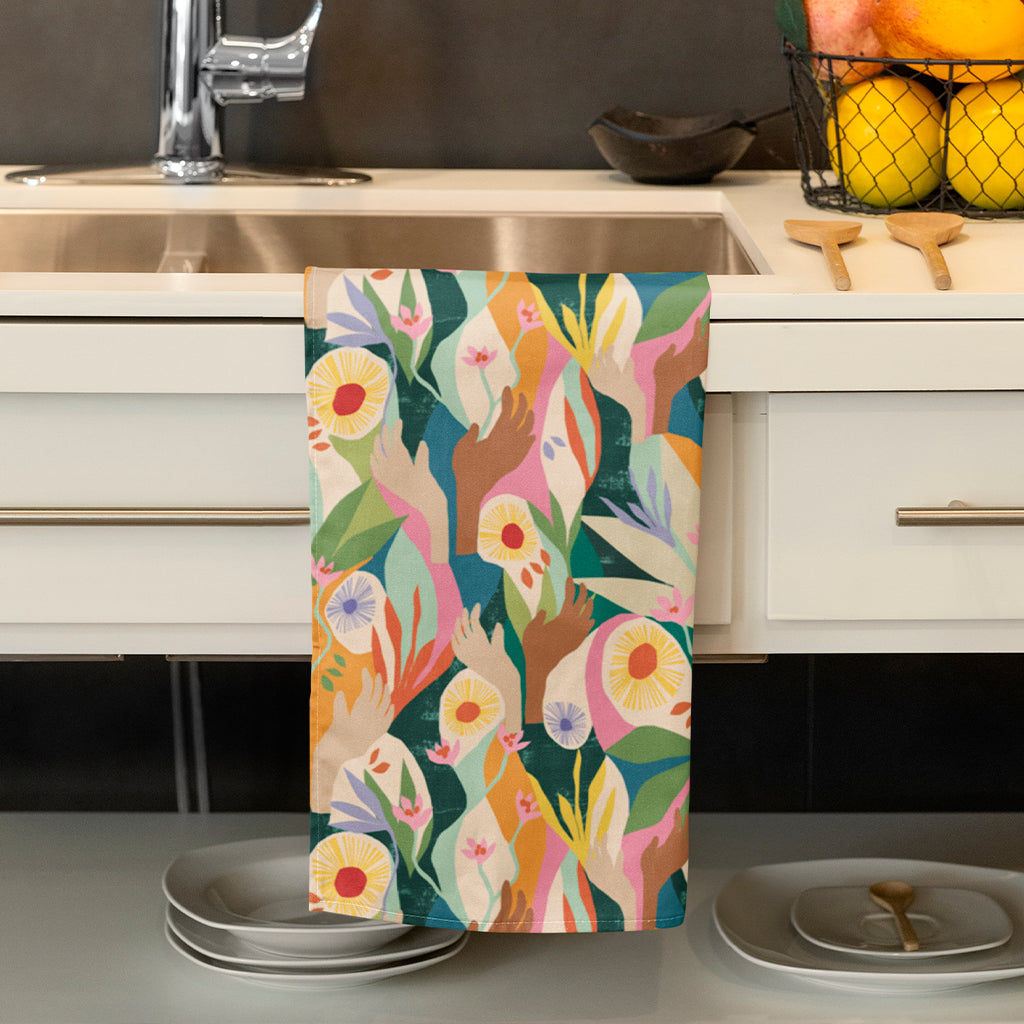 Front image of Exclusive Unity Tea Towel designed by artist Lily Windsor Walker draped over a sink