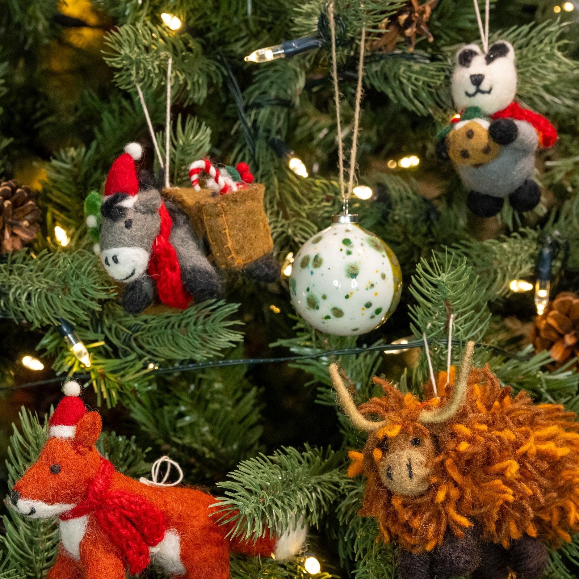 Front view of a Christmas tree with multiple Christmas decorations including Badger with Christmas Pudding