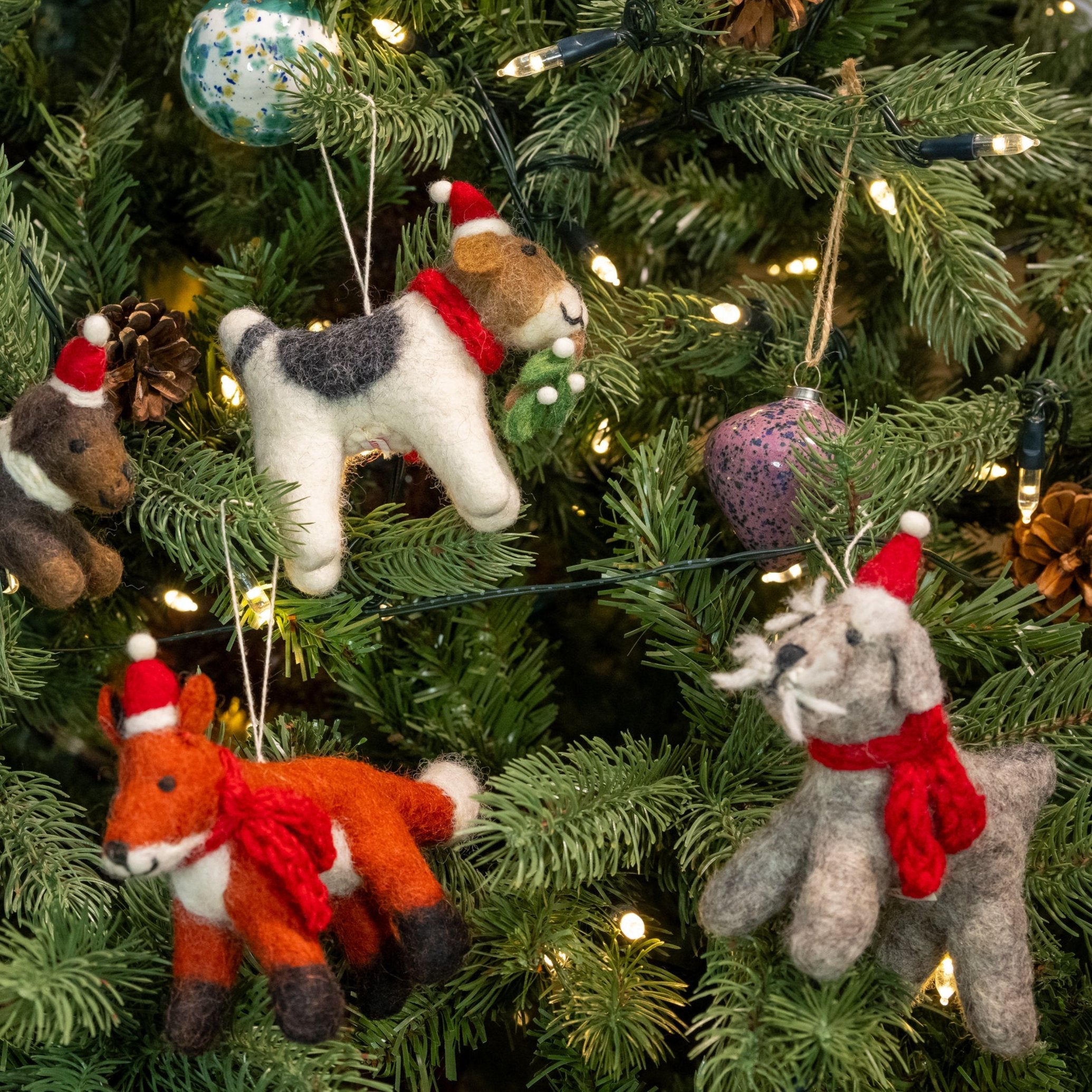 View of Schnauzer with Hat and Scarf, on a Christmas tree with other decorations and baubles