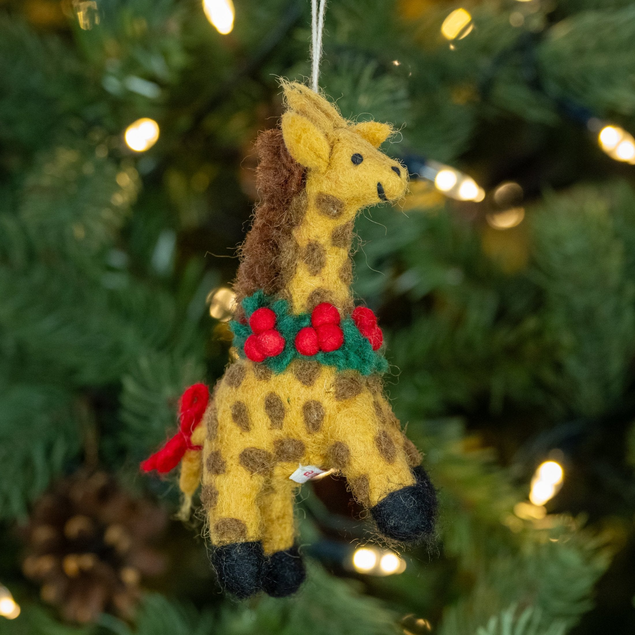 Side view of Giraffe with Holly Wreath Handmade, Fairtrade Felt Christmas Decoration