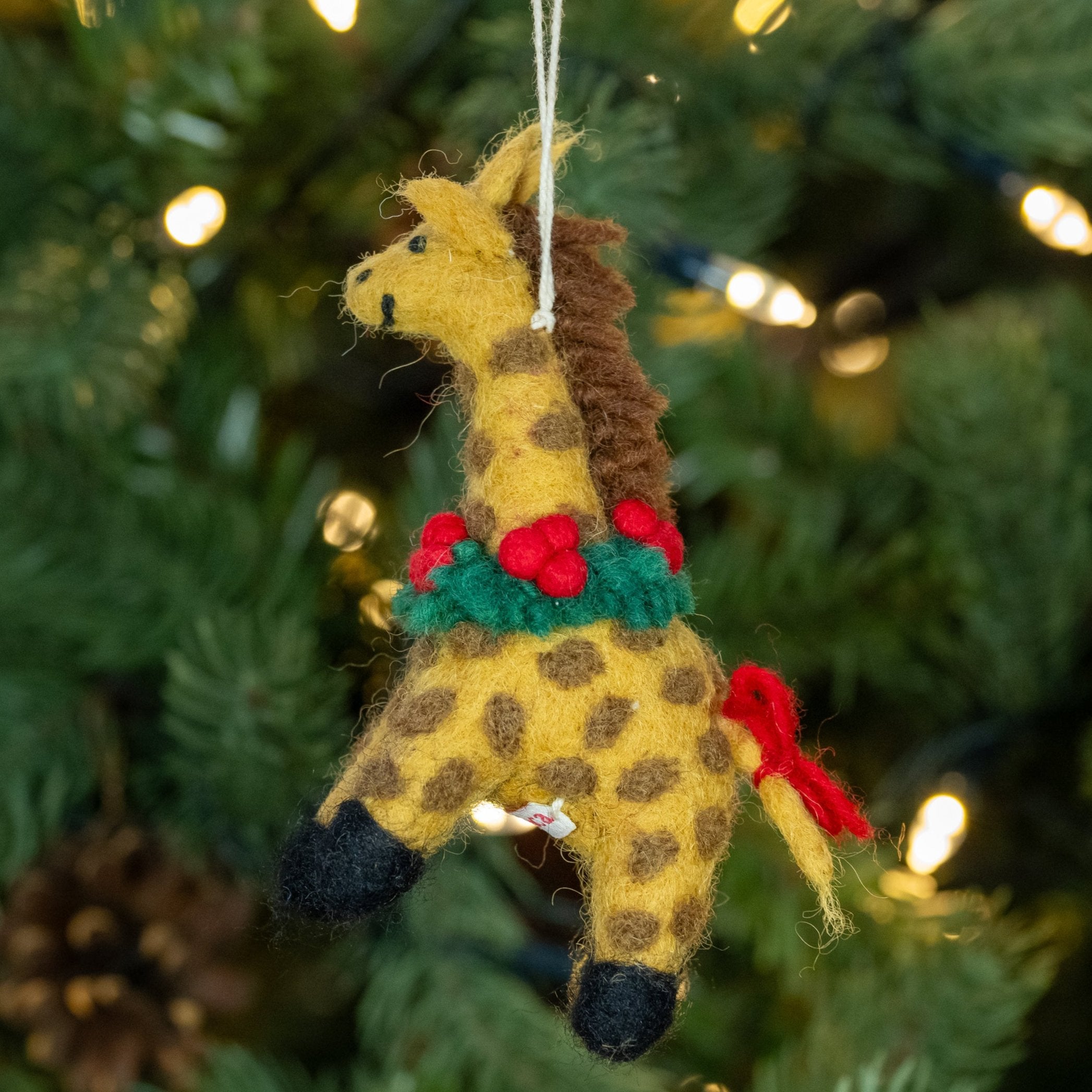 Side view of Giraffe with Holly Wreath Handmade, Fairtrade Felt Christmas Decoration