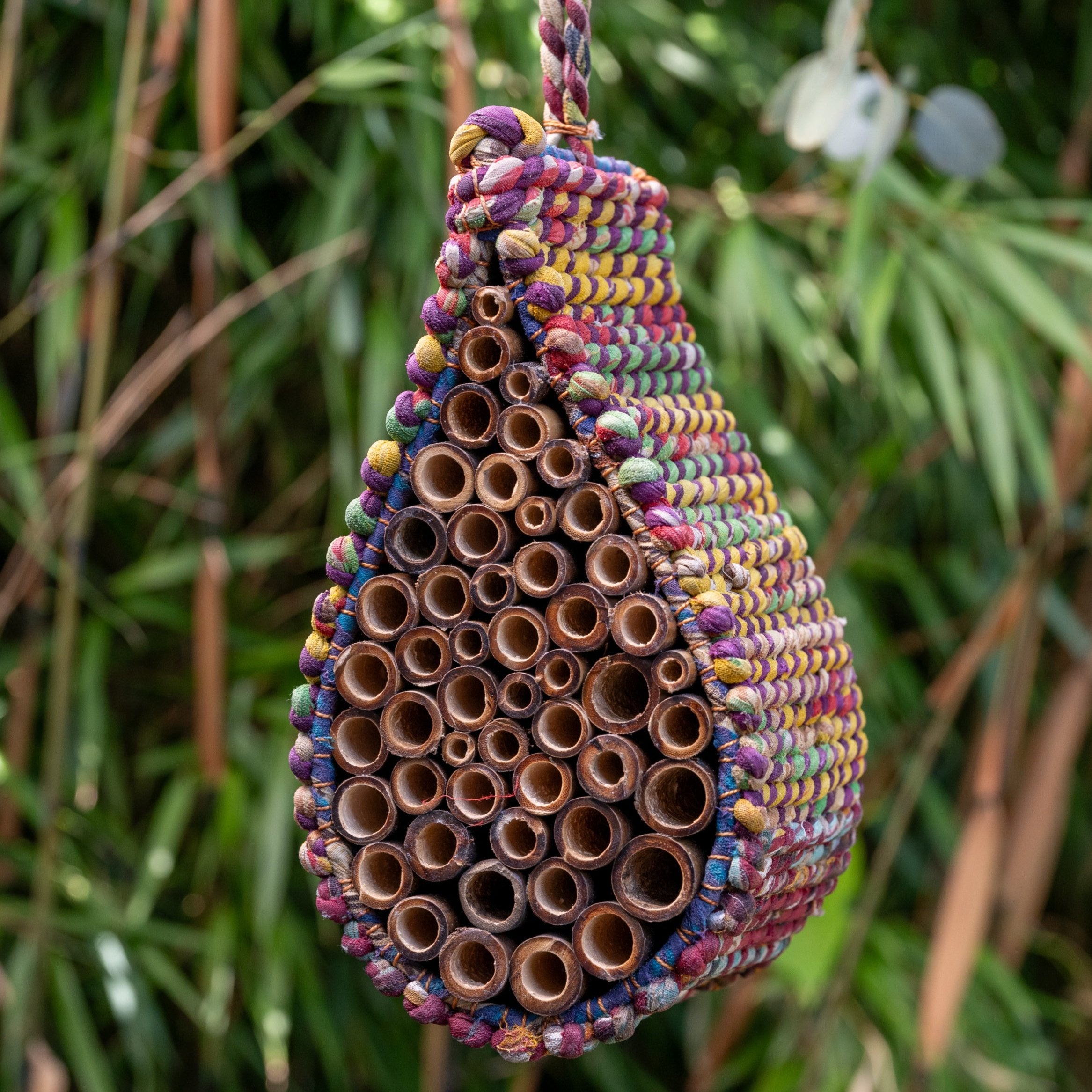 Image of multicoloured Artisan Bee Nester hanging among greenery